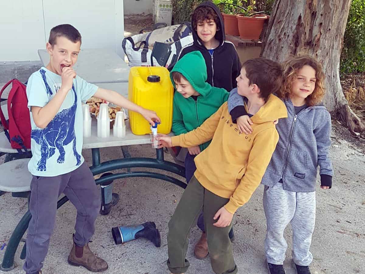 התלמידים מחלקים קפה לחברי הקיבוץ